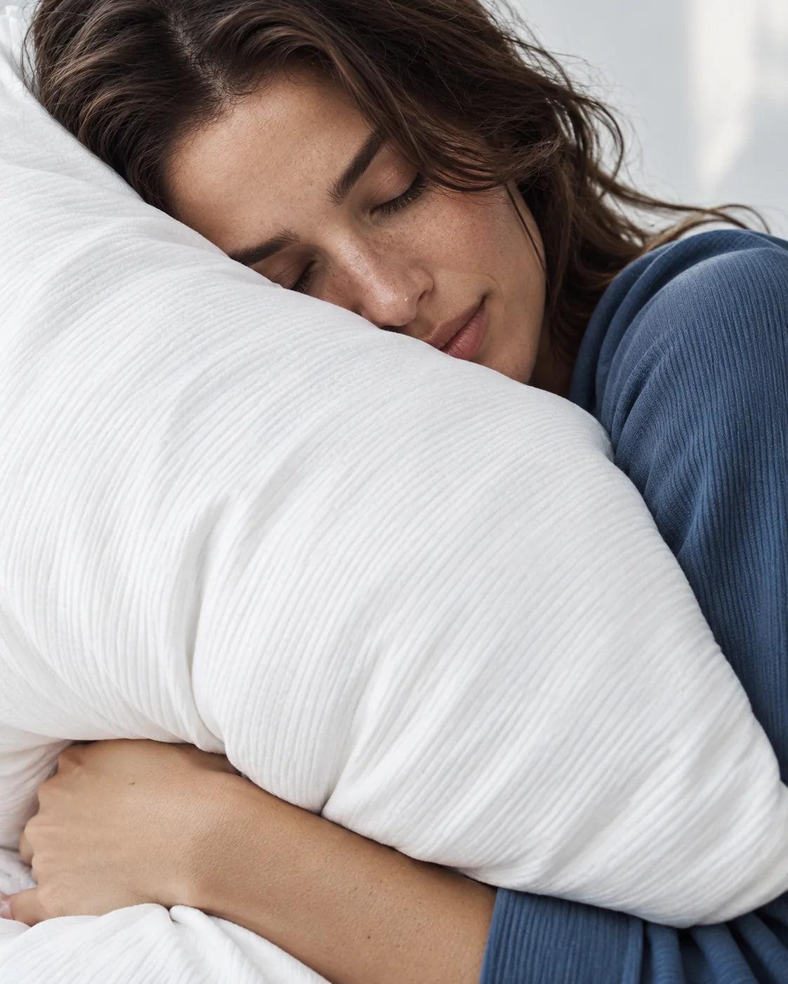 A woman resting against a white pillow.